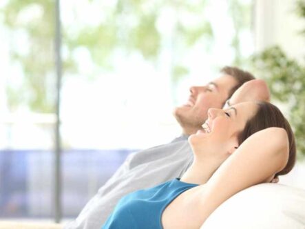 a couple in a happy mood sitting on a couch.